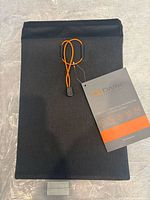 Front view of GoDark Faraday sleeve with orange cord and hang tag