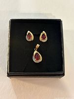 Front view of pendant and earrings in box