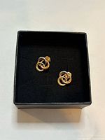 Front view of both knot stud earrings in box