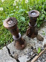 Top view of two cast iron screw jack stands showing knurled pads and rust