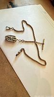 Full view of rope chain with T-bar, both swivel clasps, and locket