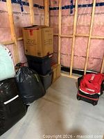 Bedding packed in totes, boxes and garbage bags with Yamaha rolling duffel bag on wheeled base