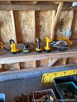 All five Dewalt cordless tools and charger on bench