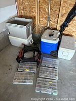 Group of fishing gear showing three rods, five tackle boxes, soft tackle bag and three coolers