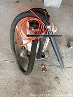 Full view of Shop-Vac with hose, wand, nozzle and extension cord visible