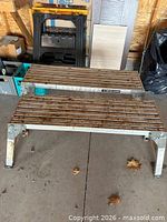 Two metal step benches and one plastic saw horse visible on workshop floor
