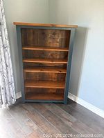 Front view of the wooden bookshelf showing painted frame and natural wood shelves