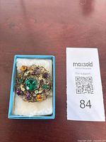 Brooch in box showing overall design and stones