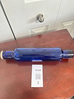 full side view of cobalt blue glass rolling pin with cap
