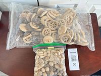 Two zip bags of assorted unfinished wooden craft parts on table