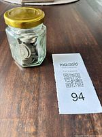 Jar filled with coins next to lot tag