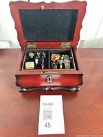 Overall view of wood jewelry box with interior tray and contents visible