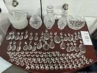 Full lot laid out on table: vases, bowls, prisms, garlands