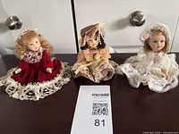 All three dolls lined up on table for scale reference