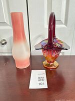 Front view of pink frosted lamp chimney and iridescent carnival glass basket