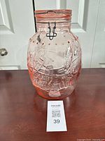Full view of pink glass jar with wire bail lid