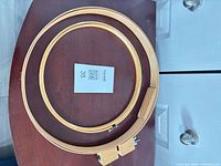 Both wooden embroidery hoops side by side on table