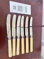 Six knives displayed blade up showing markings