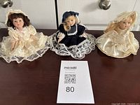 Group shot of three porcelain dolls on table