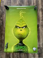 Full view of poster held at corners by weights showing complete artwork