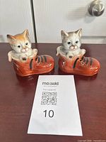 Both cat-in-boot figurines side by side