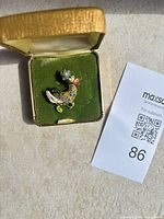 Front view of enamel and rhinestone duck brooch in box