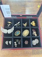 Open display box showing all twelve jewellery pieces arranged in individual compartments