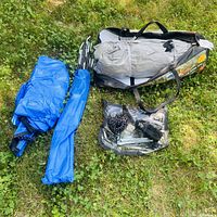 Packed tent in carry bag, pole bag and accessory pouch displayed on grass