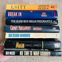 Stack of seven hardcover books showing spines and titles