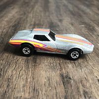 Left side profile of metallic silver Hot Wheels Corvette Stingray with stripe graphics