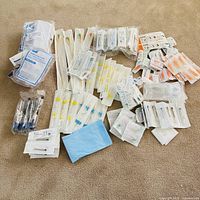 Overview of entire assortment of packaged medical supplies spread on carpet