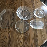 All five clear glass trays and platters on table