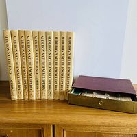 All ten encyclopedia volumes standing with slipcase drawer visible