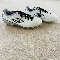 Side view showing Umbro logo, white upper, molded studs