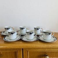 All six cup and saucer sets displayed