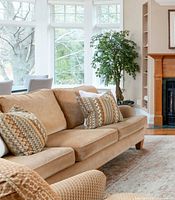 full view of tan three-seat chenille sofa with cushions in living room