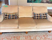 Full front view of beige chenille sofa with pillows