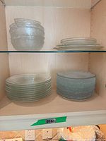 shelf showing frosted bowls and clear small plates