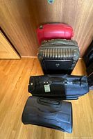 Four suitcases stacked upright showing colors and styles