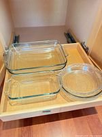 Drawer containing two rectangular Anchor glass baking dishes and stack of round glass pie plates