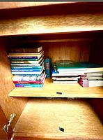 Entire cabinet shelf showing stacked books of various sizes and colors