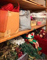 Shelving with assorted ribbon, gift bags, greenery, ornaments