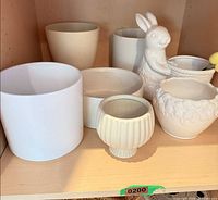 Shelf with all seven ceramic planters in various shapes and sizes
