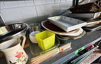 Overview of assorted platters, trays, bakeware, pitcher and accessories on shelf