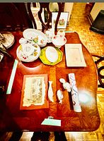 Group shot of assorted china pieces, trays, figurines, framed print and rolled poster on table