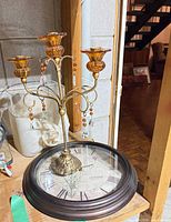 Clock face and candelabra on tabletop showing overall style