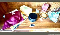 assortment on shelf showing coasters stack, wood box, book, bird clip, pink candle
