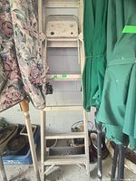 Full view of folded aluminum step ladder standing upright