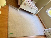 Full view of light grey wool area rug under bed