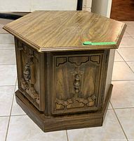 Full view of hexagonal side table showing cabinet door and shape